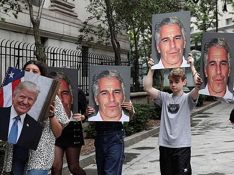 Demonstrators hold signs aloft protesting Jeffrey Epstein, as he awaits arraignment in the Southern District of New York on charges of sex trafficking of minors and conspiracy to commit sex trafficking of minors, in New York, U.S.