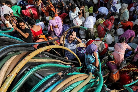 Residents fill their containers with drinking water from a municipal tanker in New Delhi, India, on July 1, 2019. 