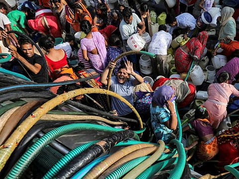 Residents fill their containers with drinking water from a municipal tanker in New Delhi, India, on July 1, 2019. 