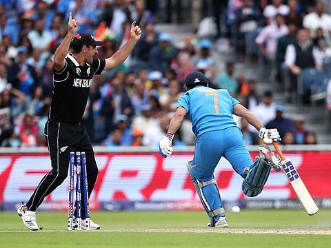Defining moment: New Zealand's Colin de Grandhomme (left) celebrates the run out dismissal of M.S. Dhoni (right) during the World Cup semi-final at Old Trafford in Manchester on July 10, 2019. This was the last time the former Indian captain was seen in an Indian shirt.