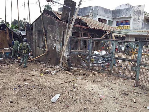 Philippine troops examine the scene of the suicide attack at a military camp in Indanan township, on the island of Jolo in Sulu province that killed five people and the bombers in the southern Philippines. 
