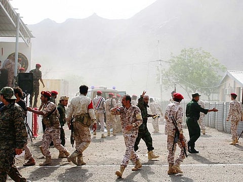 Soldiers rush to help the injured following a missile attack on a military parade during a graduation ceremony for newly recruited troopers in Aden, Yemen