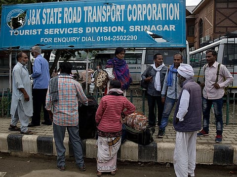 Indian pilgrims wait for transport as they prepare to leave Srinagar, on Saturday, Aug. 3, 2019. 