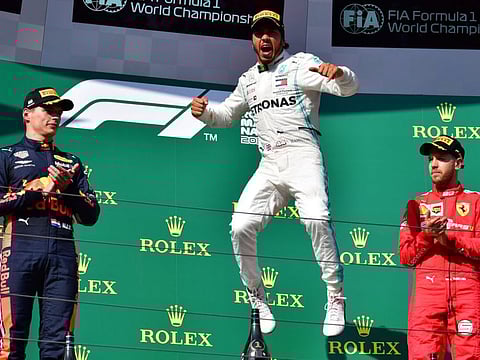 Mercedes driver Lewis Hamilton (centre) is over the moon as second placed Red Bull's Max Verstappen and Ferrari's third placed Sebastian Vettel look on at the podium. 