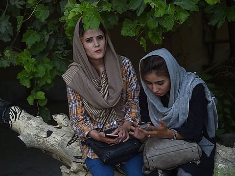 Afghan university students sit in the courtyard of the Kabul University in Kabul on August 3, 2019, as new talks between the US and the Taliban go on. Washington is hoping for a breakthrough as talks between the US and the Taliban resumed in Doha on Saturday in a bid to end 18 years of war in Afghanistan.