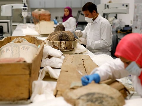 Egyptian archaeologists restore the coffin and mummy of King Tutankhamun at the conservation center in the Grand Egyptian Museum in Cairo on August 4, 2019.