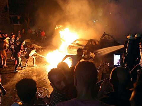 People extinguish a fire from a blast outside the National Cancer Institute, Cairo.