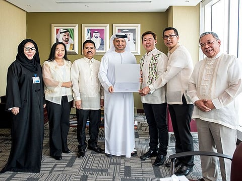 Dr. Omar AbdulAziz Al Muthanna, CEO, Regulatory and Licensing Sector of CDA, presents the licence to Filipino social Club headed by Ericson P. Reyes, President (third from right). 