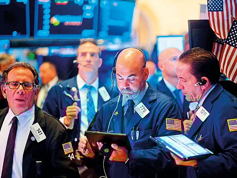 Traders work after the opening bell at the New York Stock Exchange on Monday. Selling on Wall Street accelerated as a steep drop in the Chinese yuan escalated the US-China trade war.