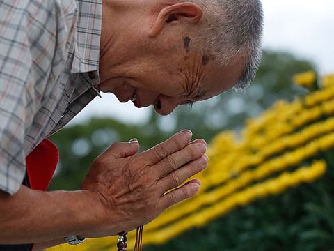 A man prays for the atomic bomb victims in front of the cenotaph at the Hiroshima Peace Memorial Park in Hiroshima, western Japan during a ceremony to mark the 74th anniversary of the bombing Tuesday, Aug. 6, 2019.