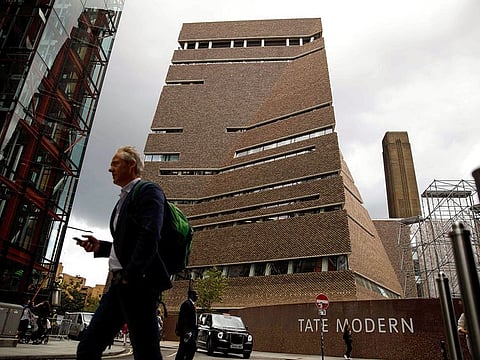 People walk past the Tate Modern gallery in central London. 