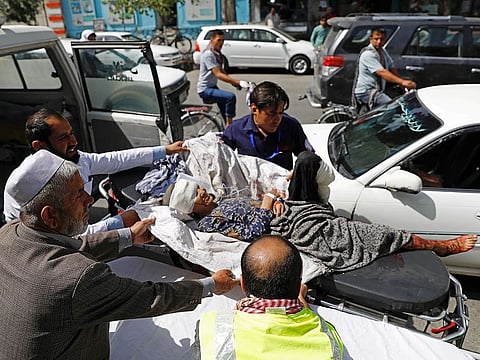 Men carry an injured woman to a hospital after a blast in Kabul, Afghanistan, August 7, 2019.