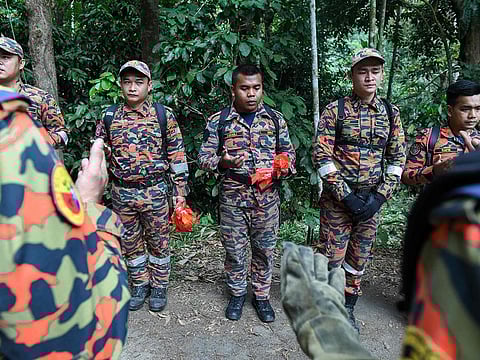 Members of Malaysian K-9 unit pray before taking part in a search and rescue operation for the missing 15-year-old Franco-Irish, Nora Quoirin in Seremban on August 7, 2019.