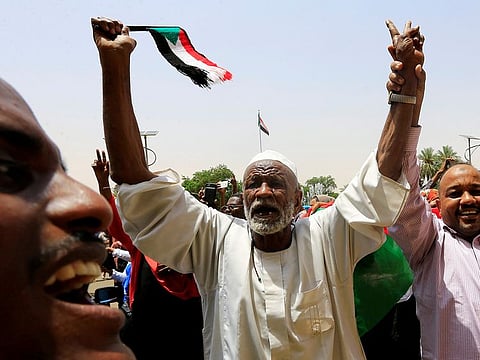 Sudanese people carry their national flag and chant slogans as they celebrate the signing of a constitutional declaration.