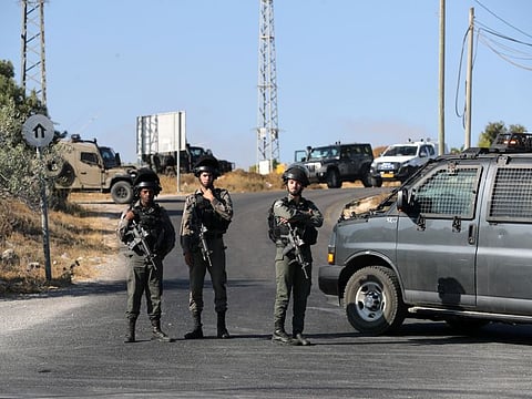 Israeli border policemen stand guard near the scene where the Israeli military said an Israeli occupation soldier was found stabbed to death near a Jewish colony outside the Palestinian city of Hebron in the Israeli-occupied West Bank on August 8, 2019. 