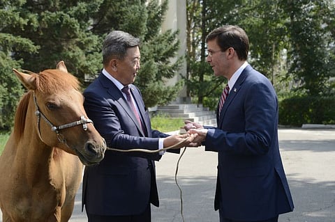 Mongolian Defense Minister Nyamaa Enkhbold, left, presents a horse as a gift to US Defense Secretary Mark Esper at the Defense Ministry in Ulaanbaatar, Mongolia on August 8, 2019.