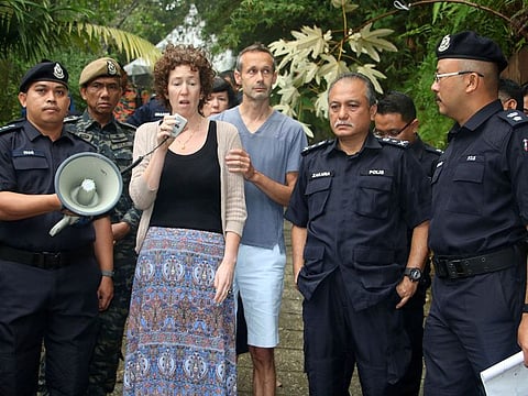Meabh Quoirin, center left, the mother of a missing British girl Nora Anne Quoirin, speaks to police officers as father Sebastien Quoirin, center right, stands beside her, in Seremban, Negeri Sembilan, Malaysia.
