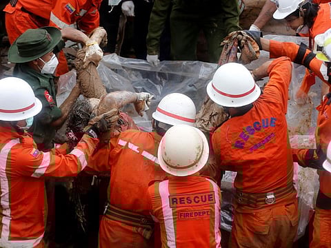  Rescue workers carry a body of a victim retrieved form the debris and mud after a landslide in Mottama, Mon state, Myanmar, August 11, 2019.