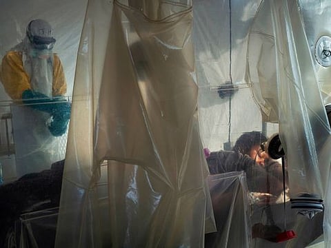 File photo: Health workers wearing protective gear check on a patient isolated in a plastic cube at an Ebola treatment center in Beni, Congo. 