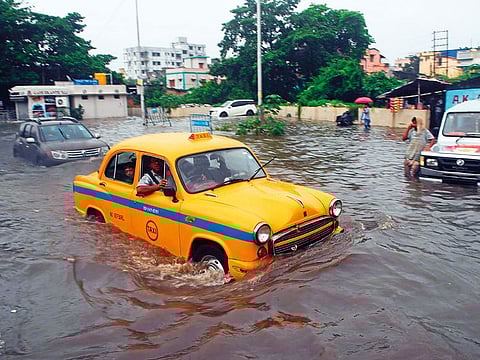 A taxi driver makes his way through a flooded street following heavy rains in Kolkata.