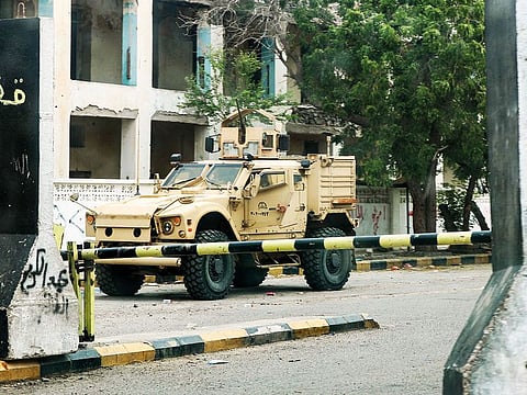 An armoured vehicle belonging to forces of the Saudi-led international coalition is seen behind security barriers at the Central Bank headquarters in the Crater district of Aden.