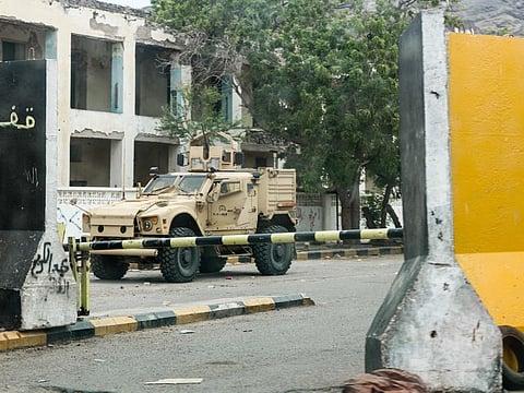 This picture taken on August 17, 2019 shows an armoured vehicle belonging to forces of the Saudi-led international coalition supporting Yemen's internationally recognised government, behind security barriers at the Central Bank headquarters in the Crater district of the second city of Aden. 