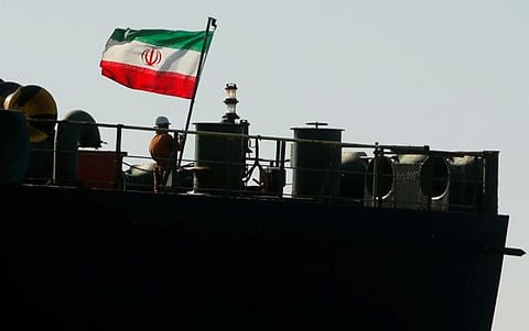 A crew member raises the Iranian flag at Iranian oil tanker Adrian Darya 1, before being named as Grace 1, as it sits anchored after the Supreme Court of the British territory lifted its detention order, in the Strait of Gibraltar, Spain, August 18, 2019.