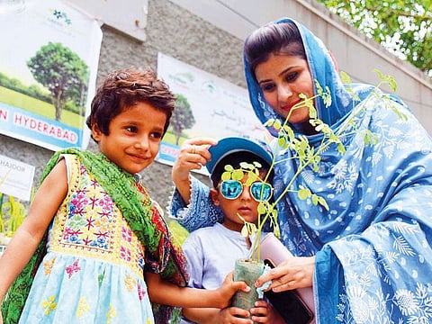 Employees of Forest department give away plants to the children, during free plants distribution among the citizens from Forest department, outside HPC.