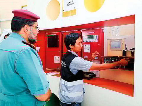 Civil Defence officials inspect fire alarm installation system at a building. 