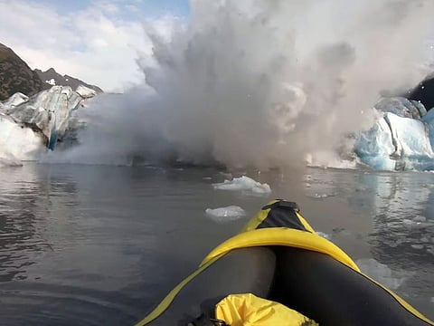The Spencer Glacier collapses, forming a big wave moments before it crashes into a kayaker.