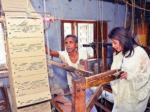 Ritu Kumar discusses the merits and problems being faced in handlooms vis-a-vis the power looms with the weaver in the unit in Benaras