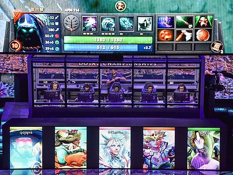 Members of team Alliance (behind glass) compete against team RNG during the International Dota 2 Championships in Shanghai.