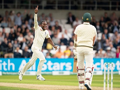 England's Jofra Archer celebrates after taking his 5th wicket, that of Australia's Pat Cummins, right.