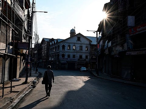 A Kashmiri man walks near closed shops in Srinagar.
