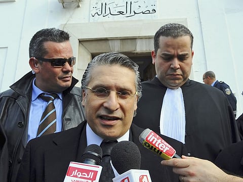 In this Jan.23 2012 file photo, the owner of the Tunisian private channel Nessma TV, Nabil Karoui, center, leaves the Tunis courthouse after attending his trial. 