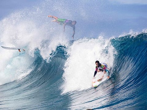 Brazilian surfers Caio Ibelli (L) and Adriano de Souza compete on the first day of the 2019 Tahiti Pro at Teahupoo, Tahiti.