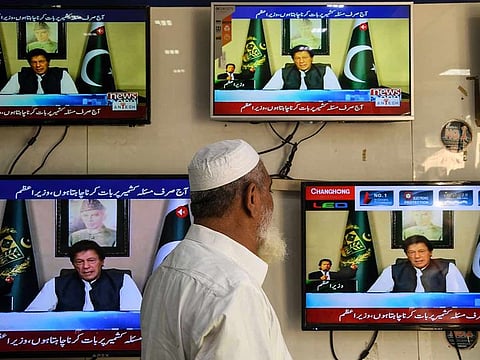  A man watches television as Pakistan's Prime Minister Imran Khan speaks to the nation on Kashmir issue, at an electronic market in Karachi on August 26, 2019