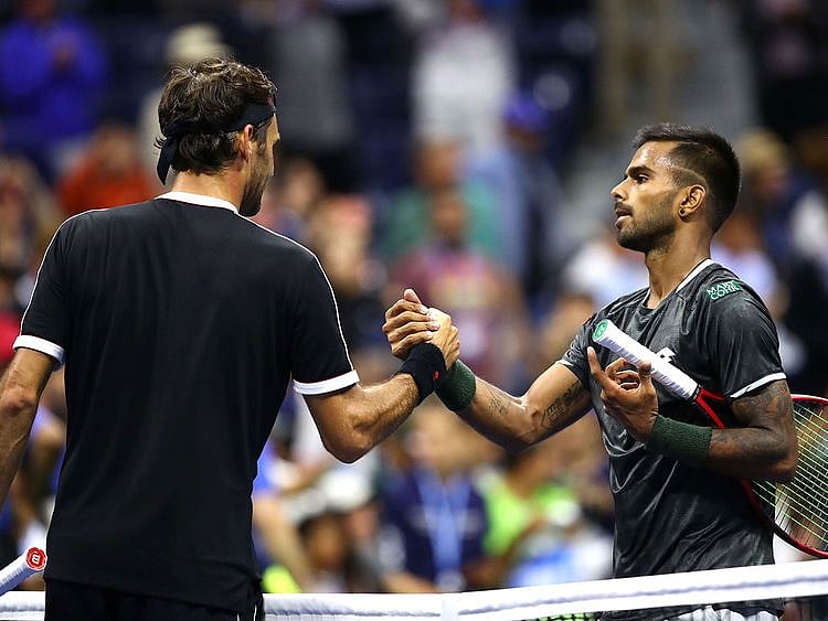 Roger Federer of Switzerland exchanges greetings with Sumit Nagal