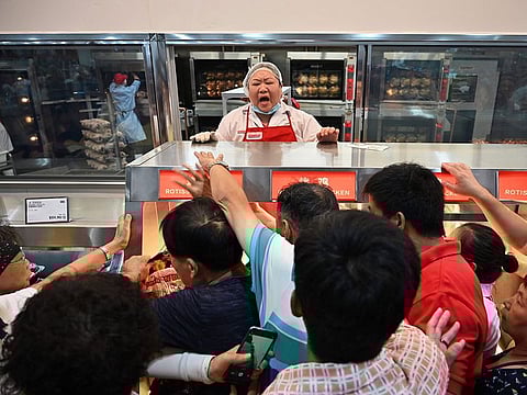 People try to get a roast chicken at the first Costco outlet in China.