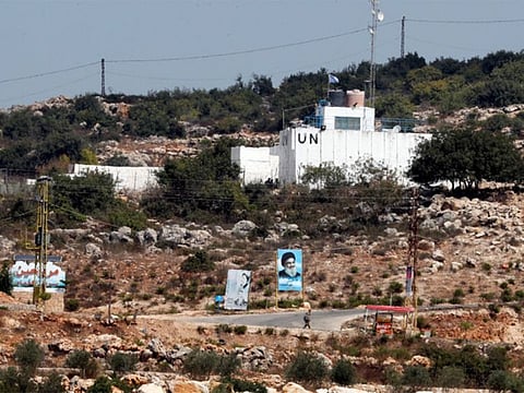 A Hezbollah banner and a UN post are seen in Lebanon from the Israeli side of the frontier, near Zar'it in northern Israel