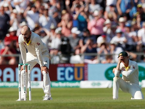 Nathan Lyon (left) looks dejected after he dropped the ball at the wicket and England's Jack Leech ran back in.