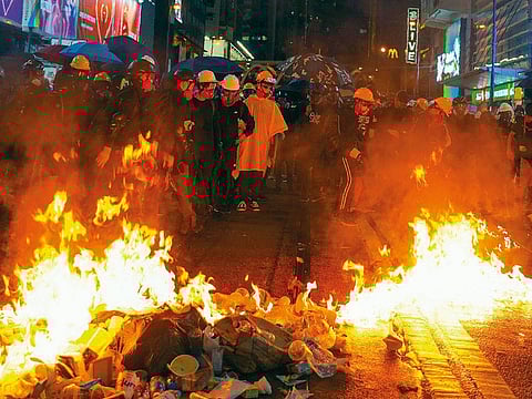 Protesters stand near burning items during a pro-democracy protest in causeway bay, Hong Kong