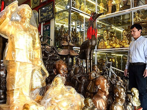A shopkeeper looking at figurines and busts of Vietnam's revolutionary leader Ho Chi Minh for sale at a shop in the old quarters of Hanoi. 