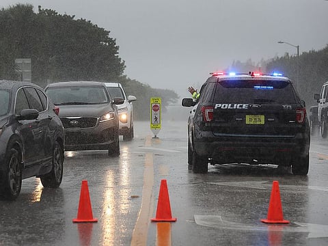 A Highland Beach police officer sits in his vehicle to check id's of people in cars as he only allows residents to enter the Highland Beach area as Hurricane Dorian continues to make its way toward the Florida coast. 