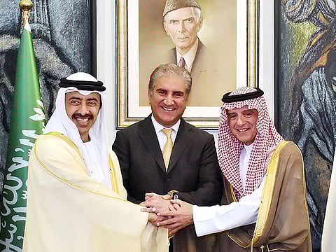 Pakistani Foreign Minister Shah Mehmood Qureshi, centre, joins hands with Saudi Foreign Minister Adel Al Jubeir, right, and UAE Foreign Minister Abdullah Bin Zayed Al Nahyan.