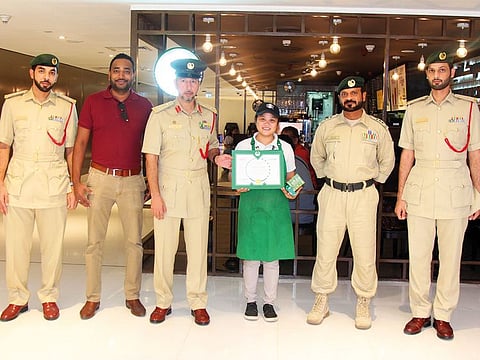Dubai Police officials with Mae Anne Olmidillo after she was honoured for her honesty.