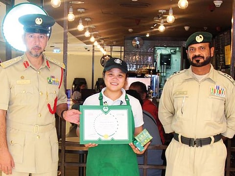 Dubai Police officials with Mae Anne Olmidillo after she was honoured for her honesty.