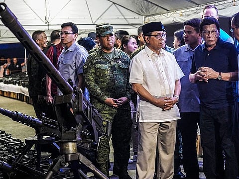 Philippine's President Rodrigo Duterte (2nd R) along with Moro Islamic Liberation Front (MILF) commander Murad Ebrahim (3rd R) and other government officials inspect handed-over weapons by MILF rebels during the decommissioning ceremony in Sultan Kudarat town, Maguindanao province, in Southern island of Mindanao on September 7, 2019. Muslim rebels in the mainly Catholic Philippines began handing over their guns to independent foreign monitors on September 7, as part of a treaty aimed at ending a decades-long separatist insurgency that has left about 150,000 people dead. 