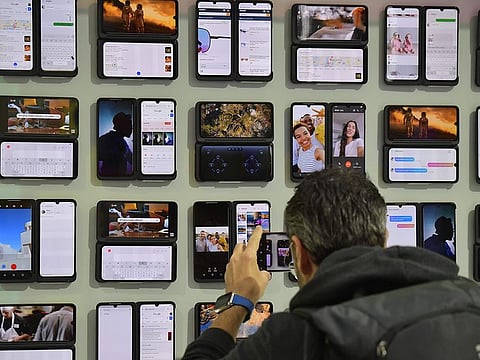 A man takes a look at mobile devices at the booth of LG during a press preview at the international electronics and innovation fair IFA in Berlin on September 5, 2019.