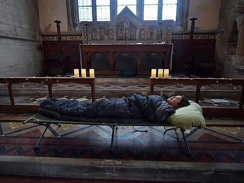 Guest Andrea Stewart tries out her bed before nightfall at St Mary's Church.